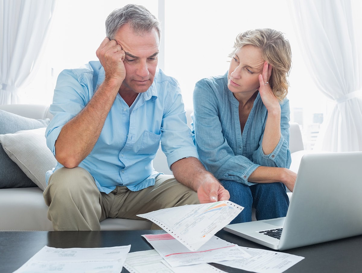 worried couple looking at utility bills